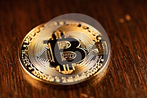 Gold Bitcoin physical coin on wooden Background. Shining digital currency coin. Cryptocurrency digital currency. Bitcoin coin.