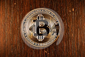 Gold Bitcoin physical coin on wooden Background. Shining digital currency coin. Cryptocurrency digital currency. Bitcoin coin.