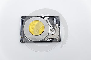 Gold bitcoin token on top of an open hard drive.Worldwide virtual internet cryptocurrency and digital payment system.Digital coin