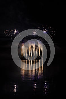 Gold and blue fountain in rich fireworks over surface of Brno`s Dam with lake reflection