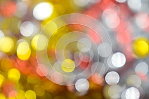 Gold bokeh background. Texture with shining blurred lights in yellow, red and silver. Abstract Christmas festive background.