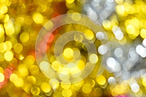 Gold bokeh background. Texture with shining blurred lights in yellow, red and silver. Abstract Christmas festive background.