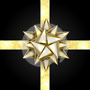 Gold bow isolated on black background. Shiny golden ribbon. Christmas satin decoration. New Year holiday design.