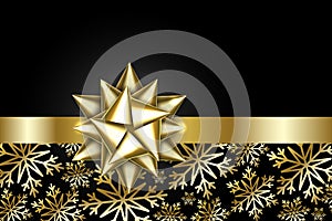 Gold bow isolated on black background. Shiny golden ribbon. Christmas satin decoration. New Year holiday design. Birthday gift.