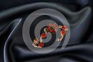 Gold bracelet on a red background with copy space