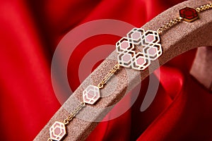 Gold bracelet on a red background with copy space