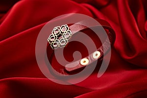 Gold bracelet on a red background with copy space