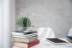 Gold brass balance scale on books in lawyer`s office. Symbol of law and justice