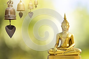 Gold Buddha statue with antique thai style bell over blurred background