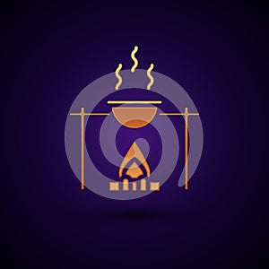 Gold Campfire and pot icon isolated on black background. Fire camping cooking in cauldron on firewood and flame. Vector