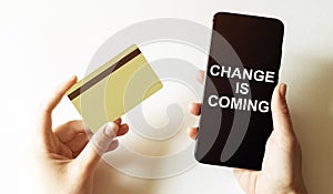 Gold card and phone with text disaster recover plan Change Is Coming in the female hands