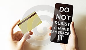 Gold card and phone with text disaster recover plan Do Not Resist Change Embrace It in the female hands