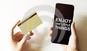 Gold card and phone with text disaster recover plan Enjoy the little things in the female hands