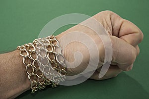 Gold chain around the male wrist. Welth concept