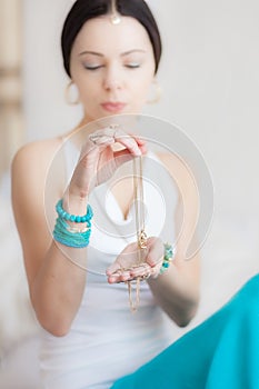 Gold chain in the hands of a young attractive oriental woman. Blurring background.