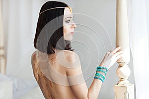 Gold chain in the hands of a young attractive oriental woman. Blurring background.