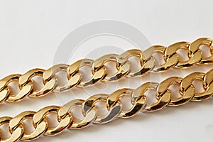 Gold chain on white background close-up, wealth luxury