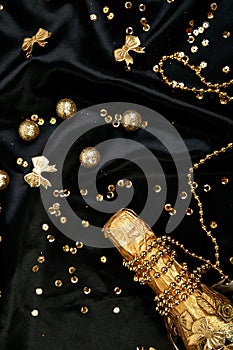 Gold Champagne bottle with confetti stars and party streamers