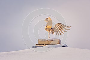 Gold Chinese phoenix bird on roof that covered white snow of Golden Pavilion at Kinkakuji Temple in winter season, Kyoto.