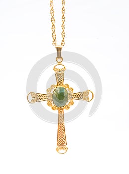 Gold Christian cross with green gem stone.