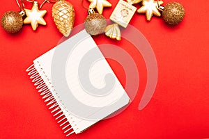 Gold Christmas balls and toys with empty blank note sheet on a red background