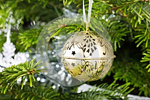 Gold Christmas bauble hanging on a Christmas tree