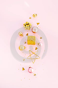 Gold Christmas decorations on a pink background flat lay , top view