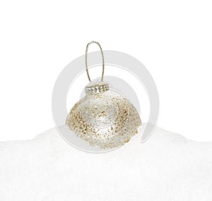 Gold Christmas New Year bauble, ball lying on the white snow
