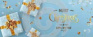 Gold Christmas and New Year Text on blue Xmas background with gift boxes, fir branches, gold ribbon, decoration, sparkles