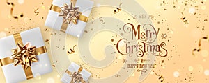 Gold Christmas and New Year Text on gold Xmas background with gift boxes, fir branches, gold ribbon, decoration, sparkles,