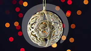 Gold Christmas ornament swing with blinking lights behind