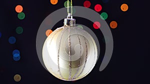 Gold Christmas ornament swing o black background with blinking lights