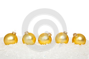 Gold Christmas ornaments in snow