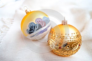 Gold Christmas toys on white knitted blankets. Golden painted balls newyear decor, selective focus