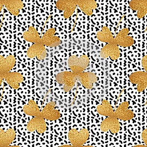 Gold clover leaves on black doodle spots background. Shamrock seamless pattern for Saint Patrick's Day designs.