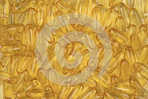 Gold cod liver fish oil capsule, vitamin D on background