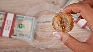 Gold Coin of Bitcoin on the Background of One Hundred Dollar Bills