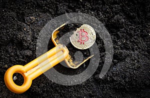 gold coin bitcoin with shovel in soil