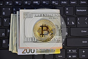 bitcoin coin and dollars on keyboard