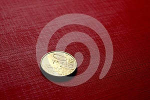 Gold coin on red surface
