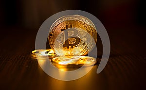 Gold coins of bitcoins on an office table on a dark background