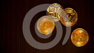 Gold coins of bitcoins on an office table on a dark background