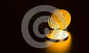 Gold coins of bitcoins on an office table on a dark background