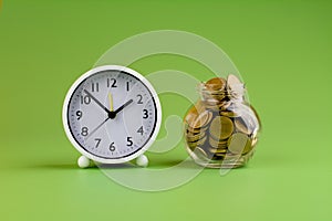 gold coins in glass jars on green background, coin savings concept