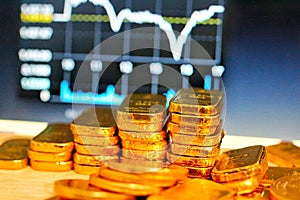 Gold coins, gold bars, sorting, concept, saving, education, gold investment  Forex trading, stock table background blur