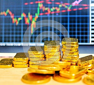 Gold coins, gold bars, sorting, concept, saving, education, gold investment  Forex trading, stock table background blur