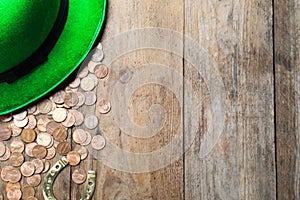 Gold coins, horseshoe and green leprechaun hat on table, flat lay with space for text. St. Patrick`s Day celebration