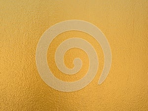 Gold color background. Rough gold texture design on the wall