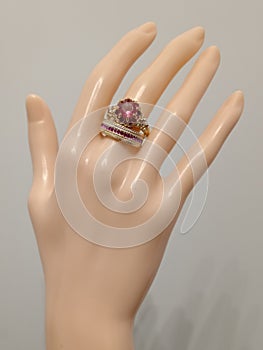 Gold color bijou rings with red stone on mannequin hand