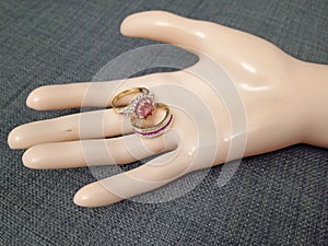 Gold color bijou rings with red stone on mannequin hand